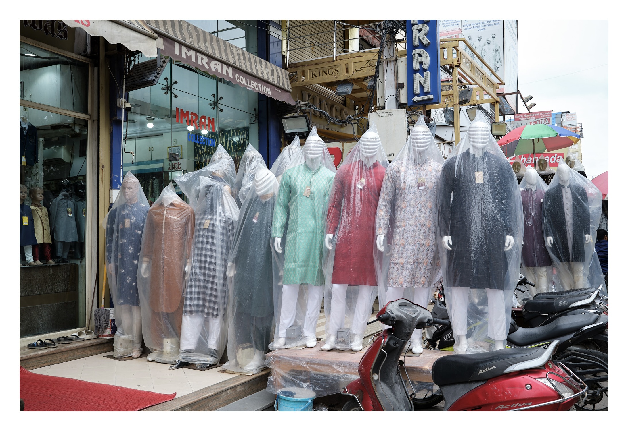 Mannequin wearing mens wedding wear but covered with polythene covers to protect them from the rain