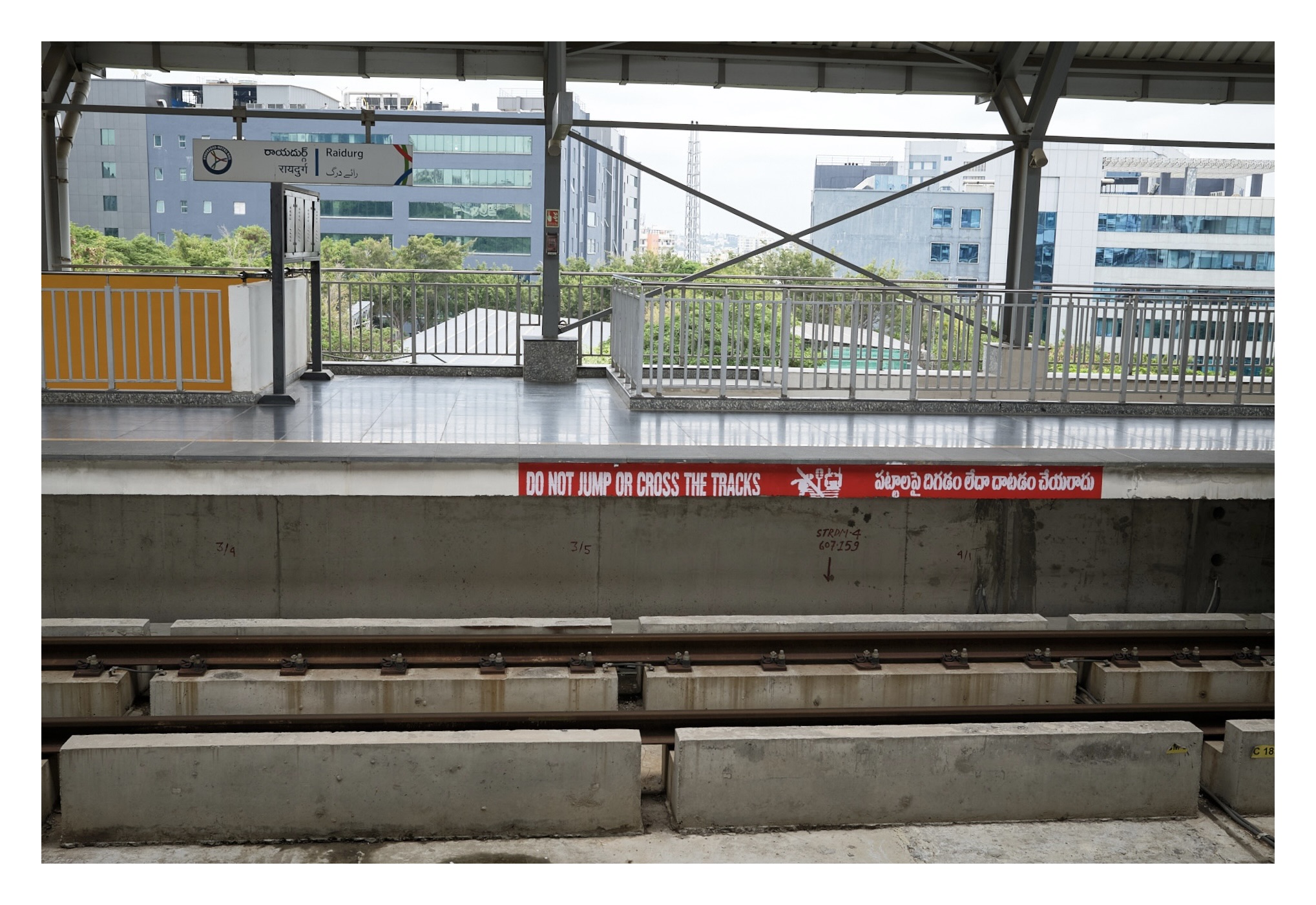 A photo from the metro station and it's track. The sides of the platform reads 'Do not jump or cross the tracks'