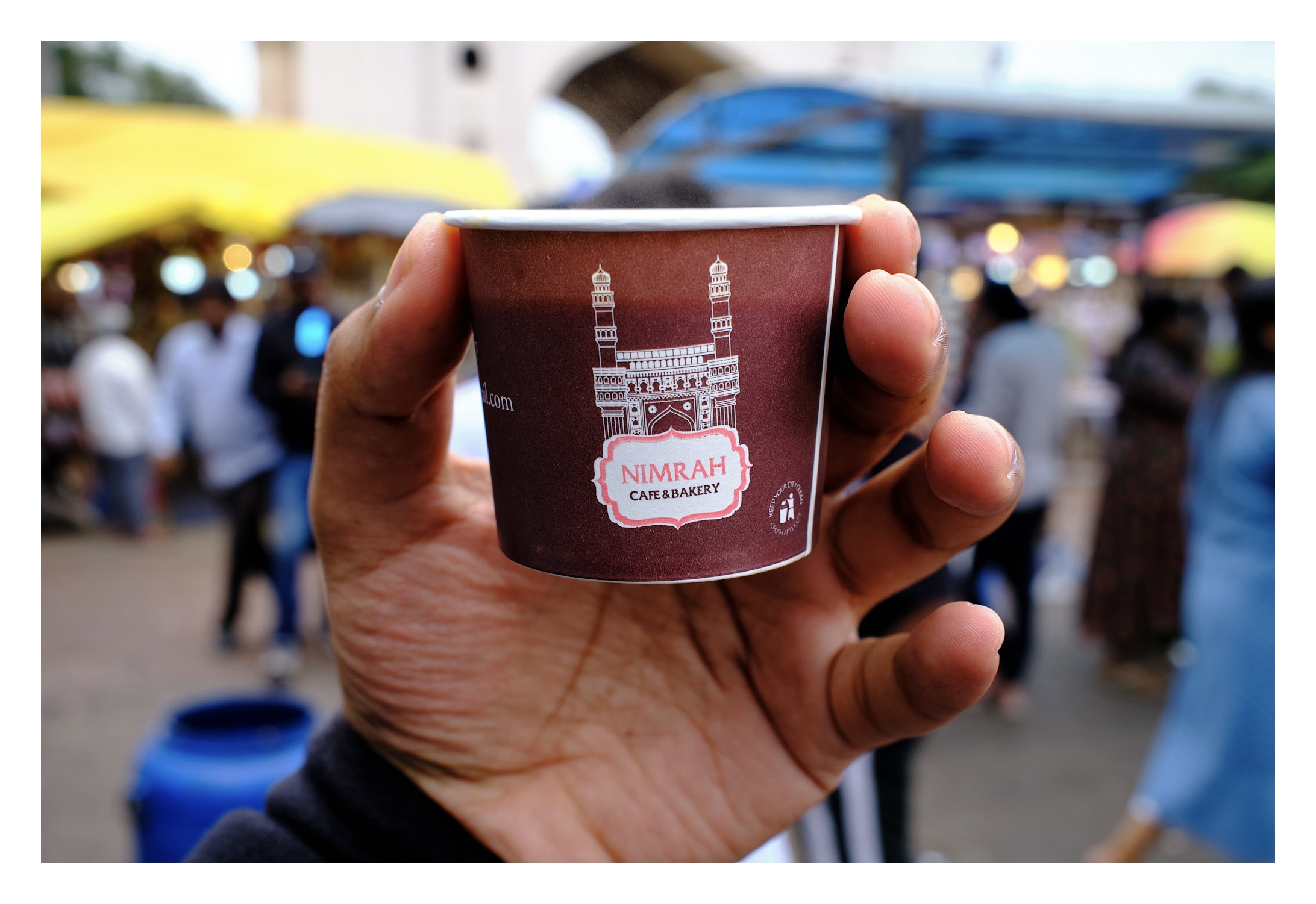 Photo of Tea cup from Nimrah Cafe, in the background there is charminar blurred