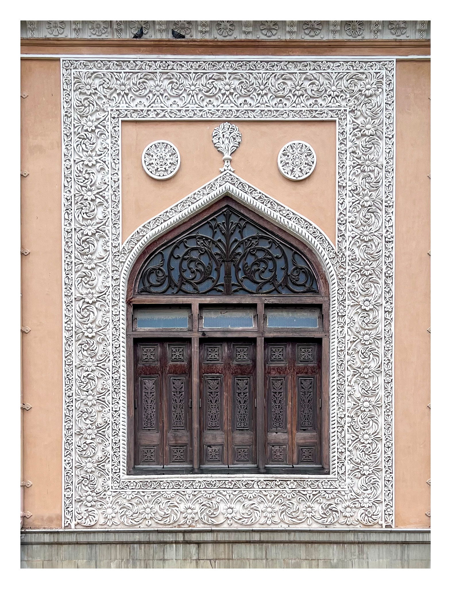 Wooden window surrounded by the decorated ornamentation of Tahniyat Mahal