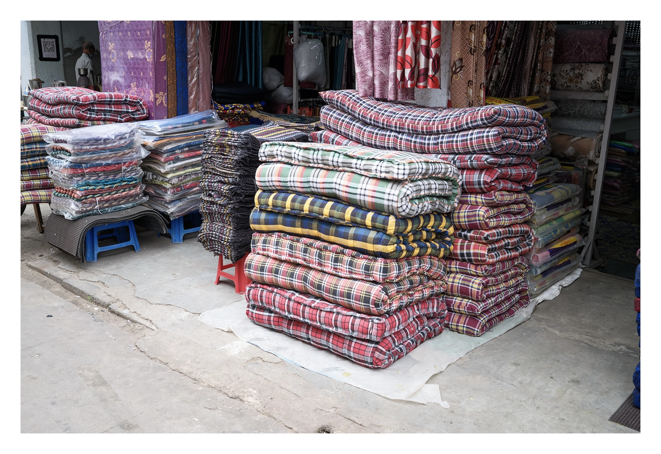 stack of colorful cotton mattresses outside of mattress store